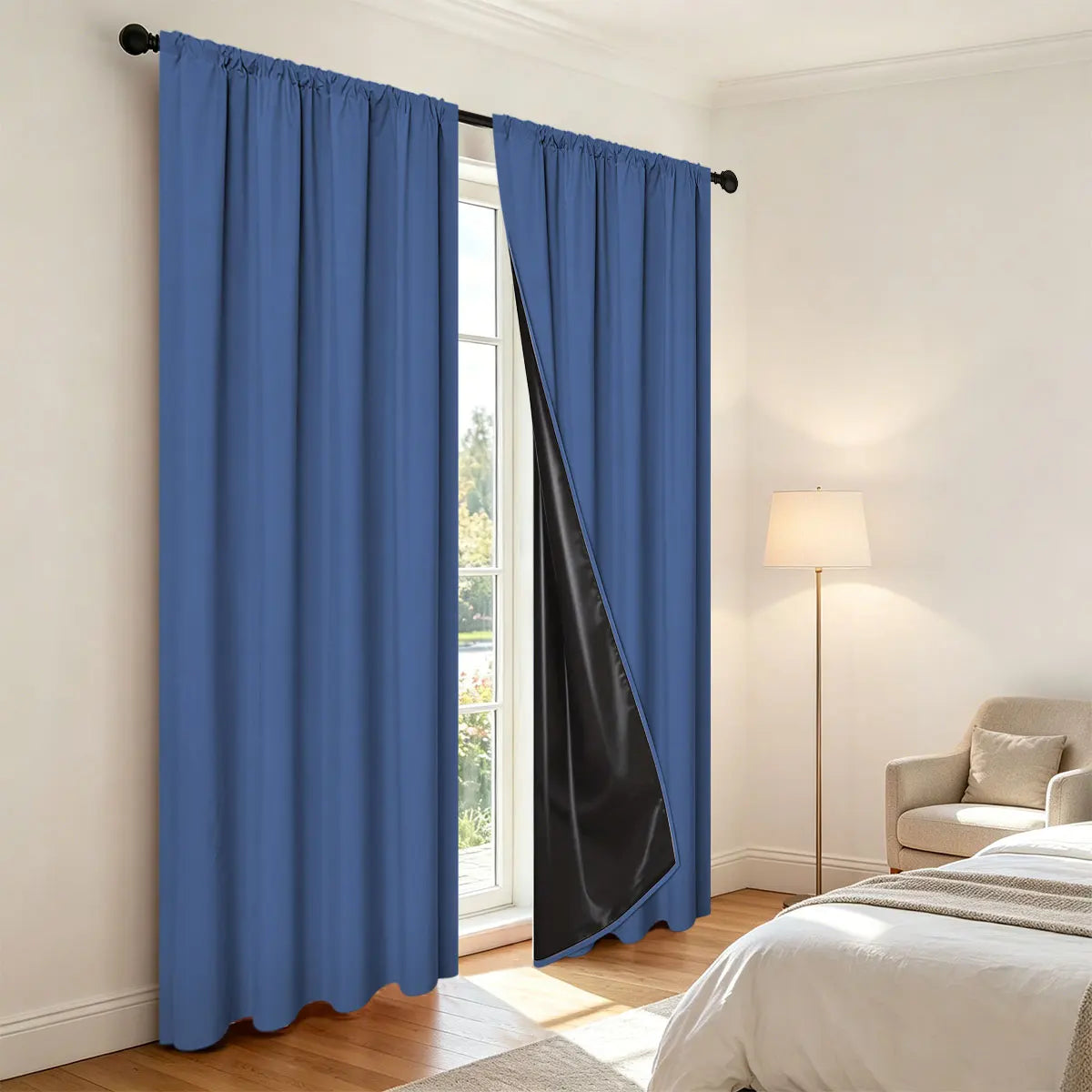 Royal blue and black blackout curtains with thermal liner hanging in a bright room.