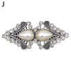 Vintage swirl clip brooch featuring a large pearl surrounded by clear rhinestones and silver-toned metalwork