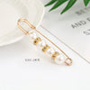 Gold-toned adjustable pearl brooch featuring multiple strands of white pearls and small diamonds