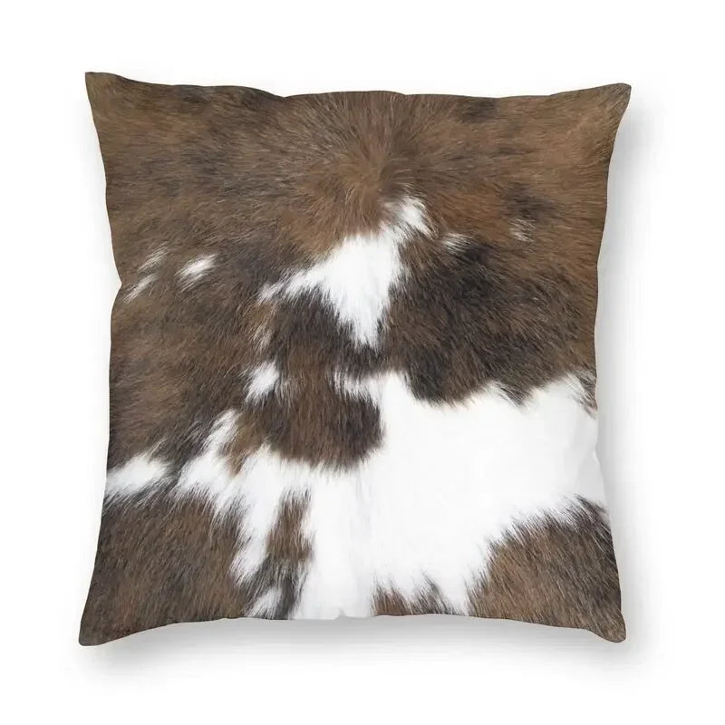 A square cushion cover featuring a brown and white faux fur cowhide print.