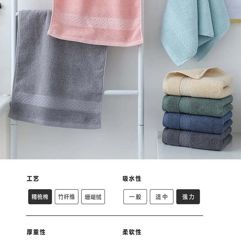 A set of six fabric face towels in various shades of gray, pink, and blue are displayed hanging on a rack.