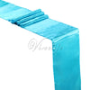 A bright turquoise satin table runner draped in folds.