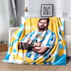 A yellow and blue blanket featuring a portrait of Lionel Messi wearing a soccer jersey.