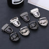 A set of silver metal bag clasps and buckles for handbags displayed on a dark surface.