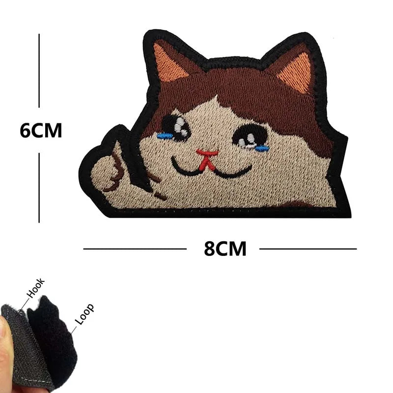 Embroidered tactical patch of a cat face with brown fur and blue eyes