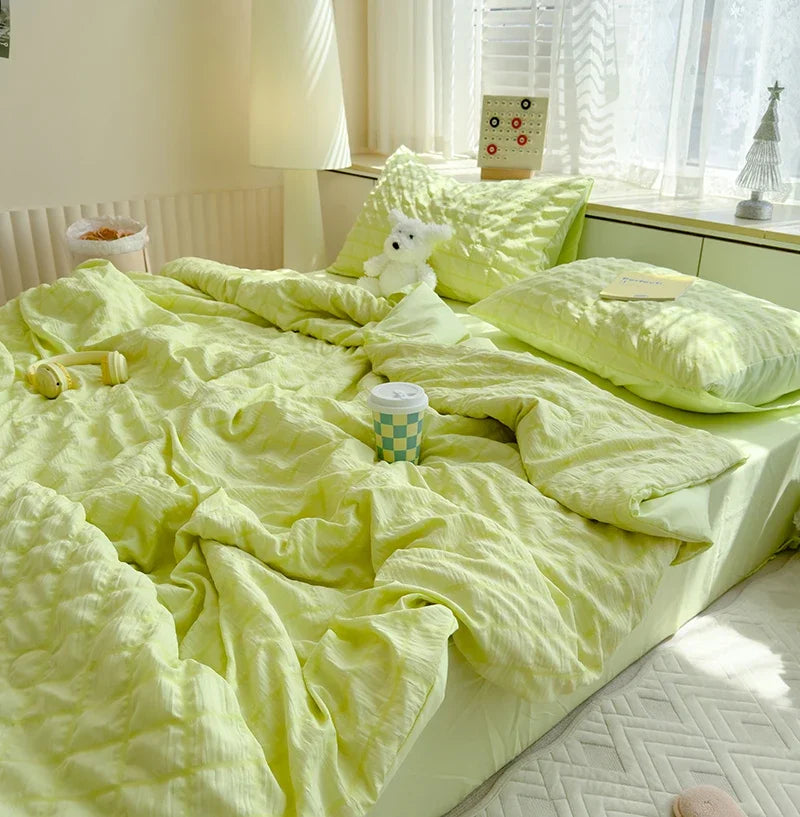 A bright lime green summer seersucker quilt comforter spread out on a bed with white curtains and a lamp.