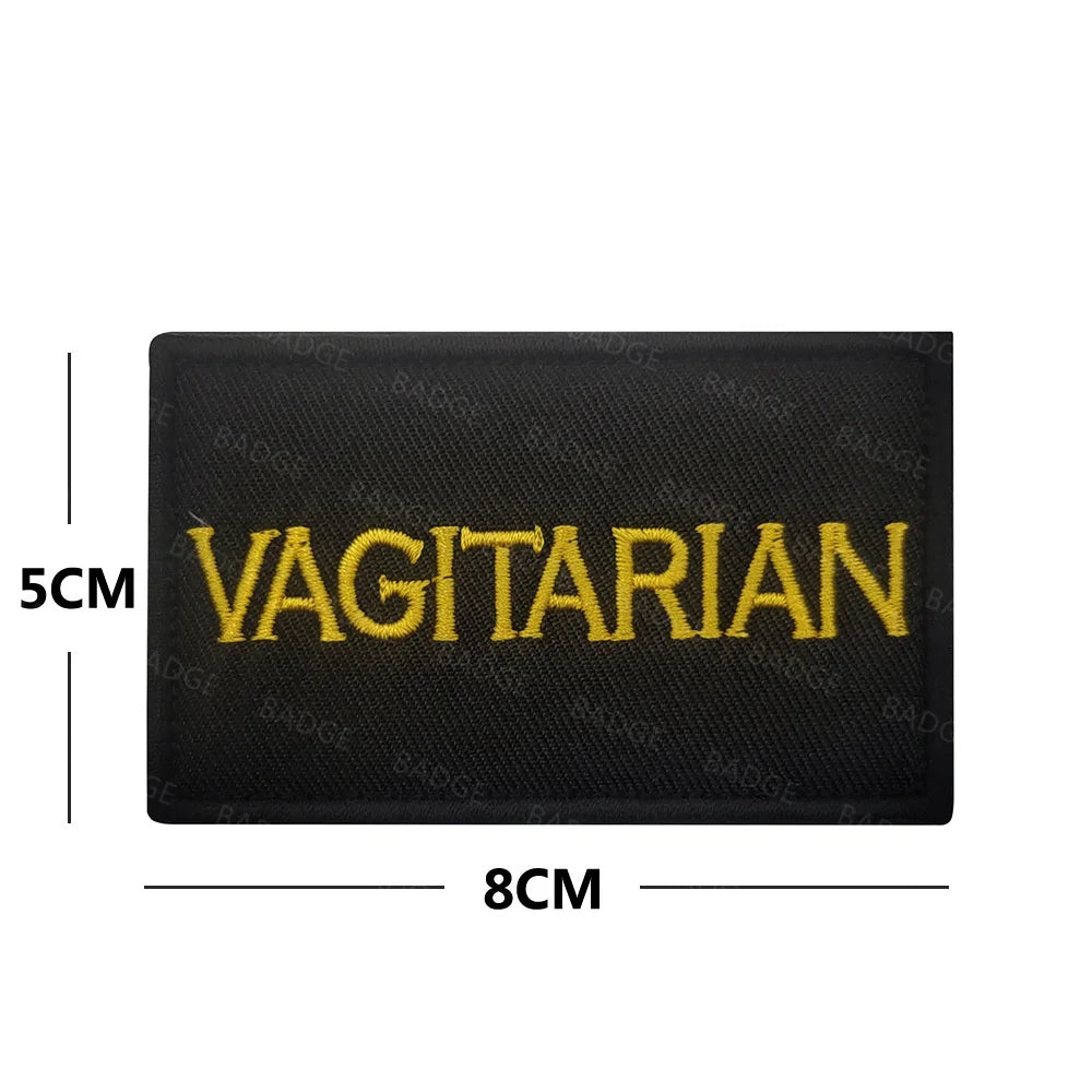 Black embroidered patch with yellow text saying VEGETARIAN