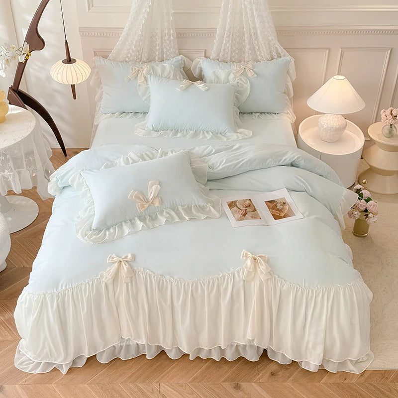A light blue princess chiffon duvet cover set with white ruffled accents and sheer canopy pillows on a bed.