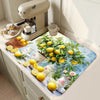 A lemon printed non-slip dish drying mat placed on a kitchen counter next to a coffee grinder and cups.