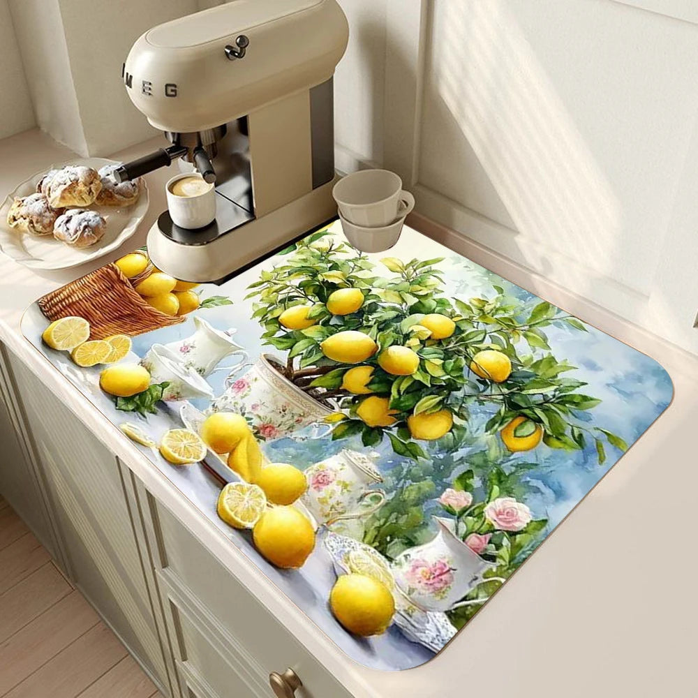 A lemon printed non-slip dish drying mat placed on a kitchen counter next to a coffee grinder and cups.