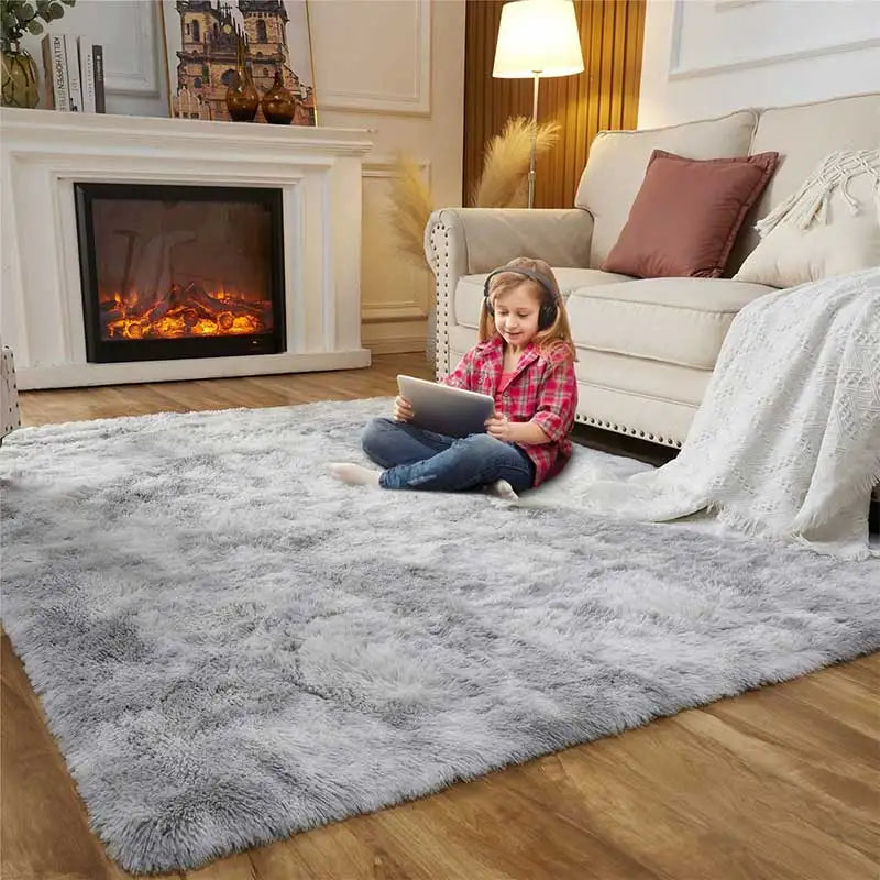A young girl sits on a gray shag rug in front of a fireplace and sofa.