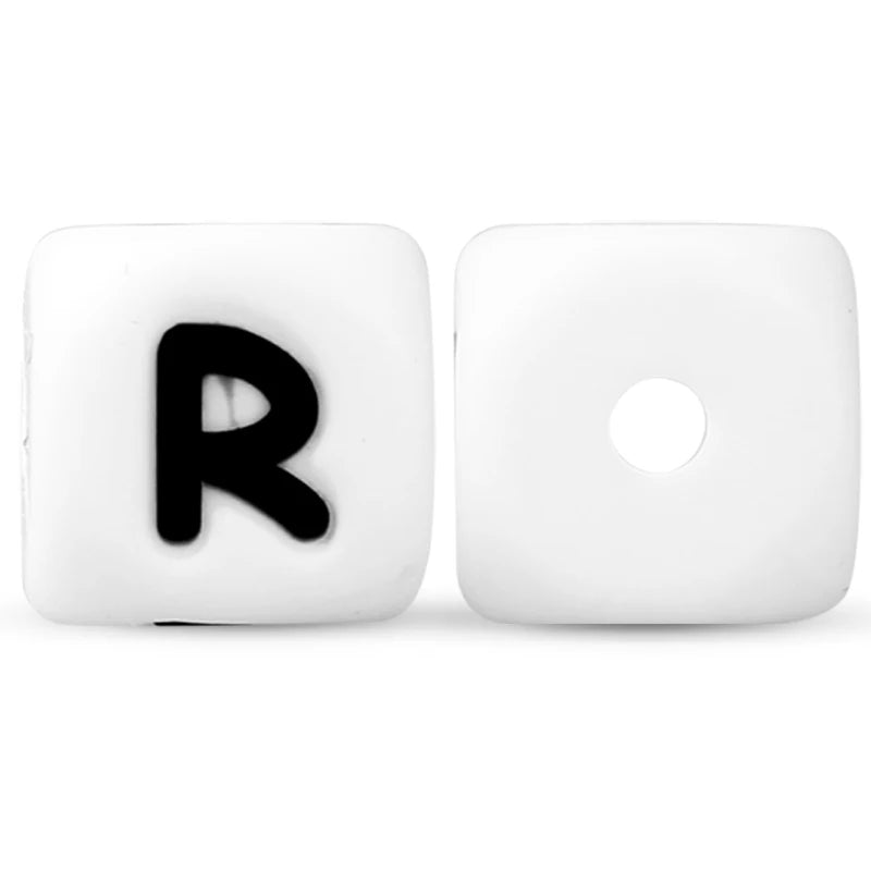 A white silicone alphabet bead shaped like the letter R with a circular hole.