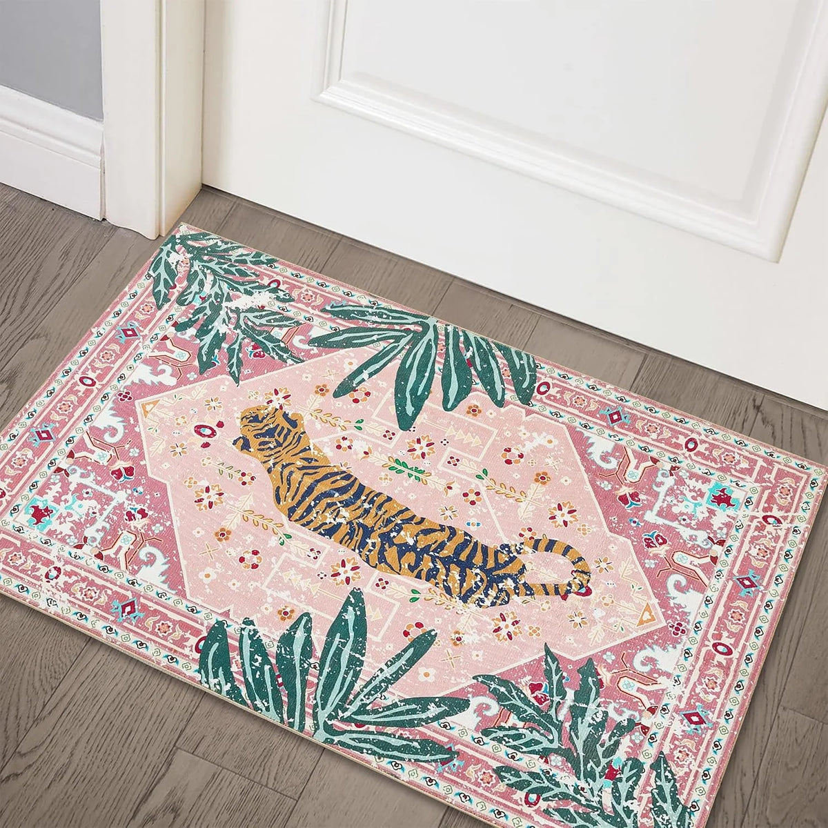 Pink tiger and tropical palm leaf non-slip entryway rug on a wooden floor.