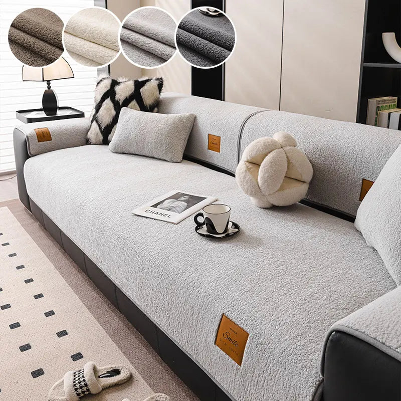 A light gray fleece sofa mat with decorative pillows and a mug placed on the surface.