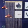 Decorative crystal beaded string curtains hanging against a dark blue wall.