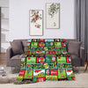 A colorful plaid throw blanket featuring Christmas and holiday themes draped on a sofa.