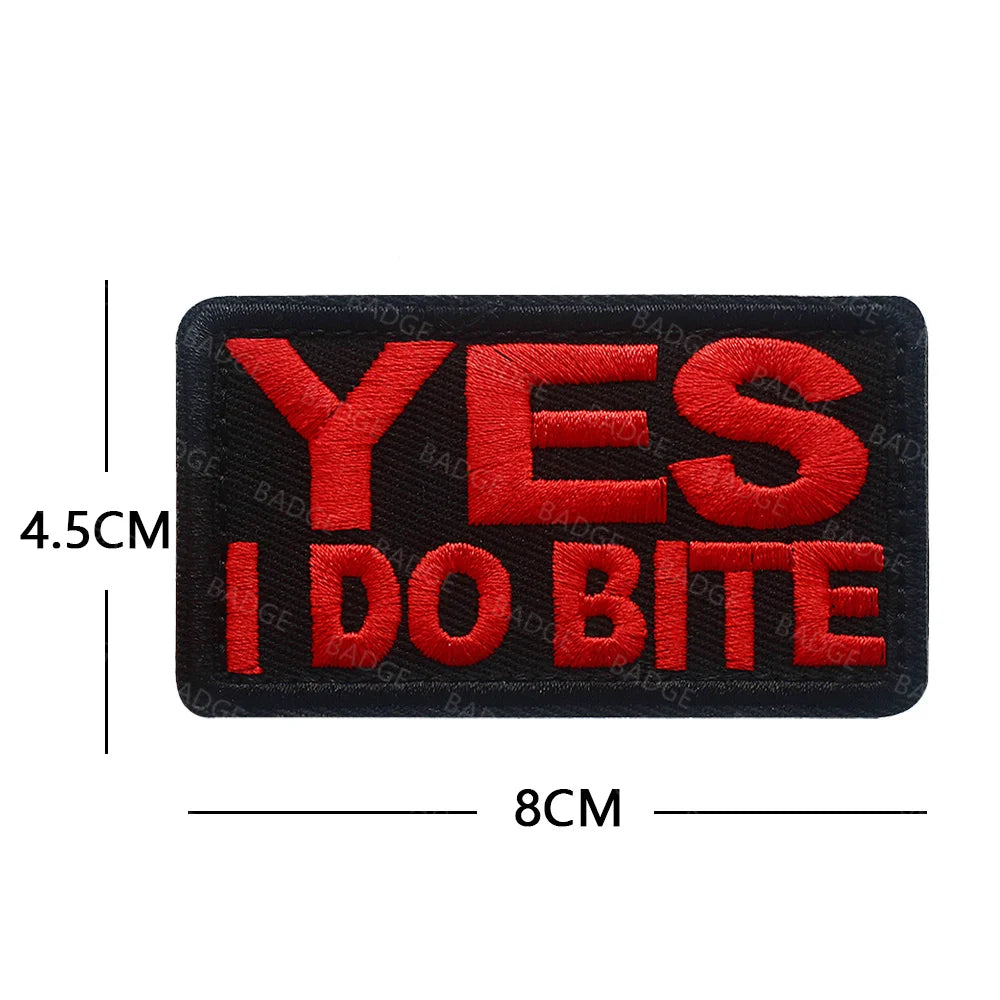 Black embroidered patch with red text saying YES I DO BITE