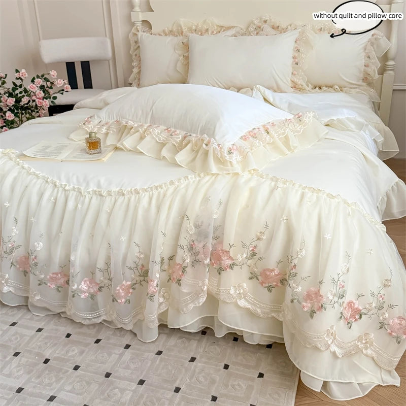 A white Korean style lace embroidered duvet set with pink floral embroidery and ruffled edges on a bed.