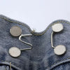 Silver metal button snaps attached to denim fabric
