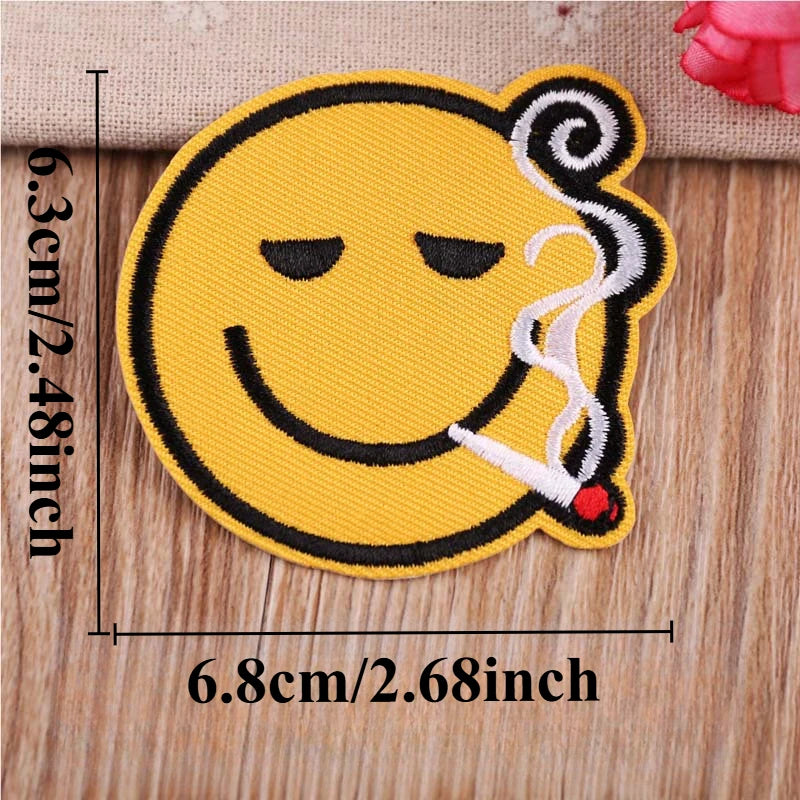 Yellow embroidered patch depicting a face with a wisp of smoke or steam.