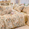 A beige floral cotton duvet cover and pillow set displayed on a bed with sheer curtains.