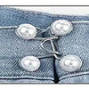 A close-up of a denim jean waistband with an adjustable alloy button clip featuring several pearl-like buttons.