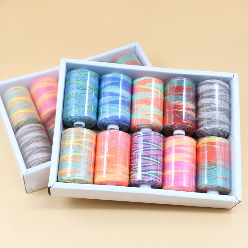 A box filled with various colorful spools of sewing thread in rainbow hues.