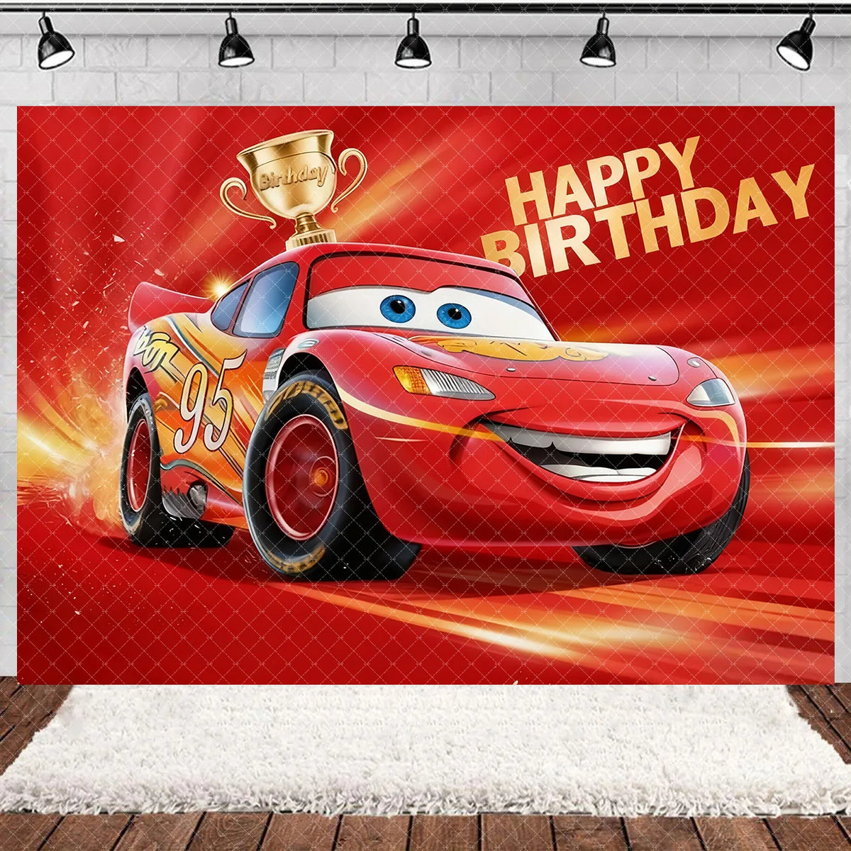 A cartoon racing car with a gold trophy is featured on a red birthday party backdrop.