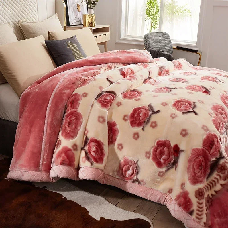 A pink and cream floral weighted blanket draped over a bed in a bright room.