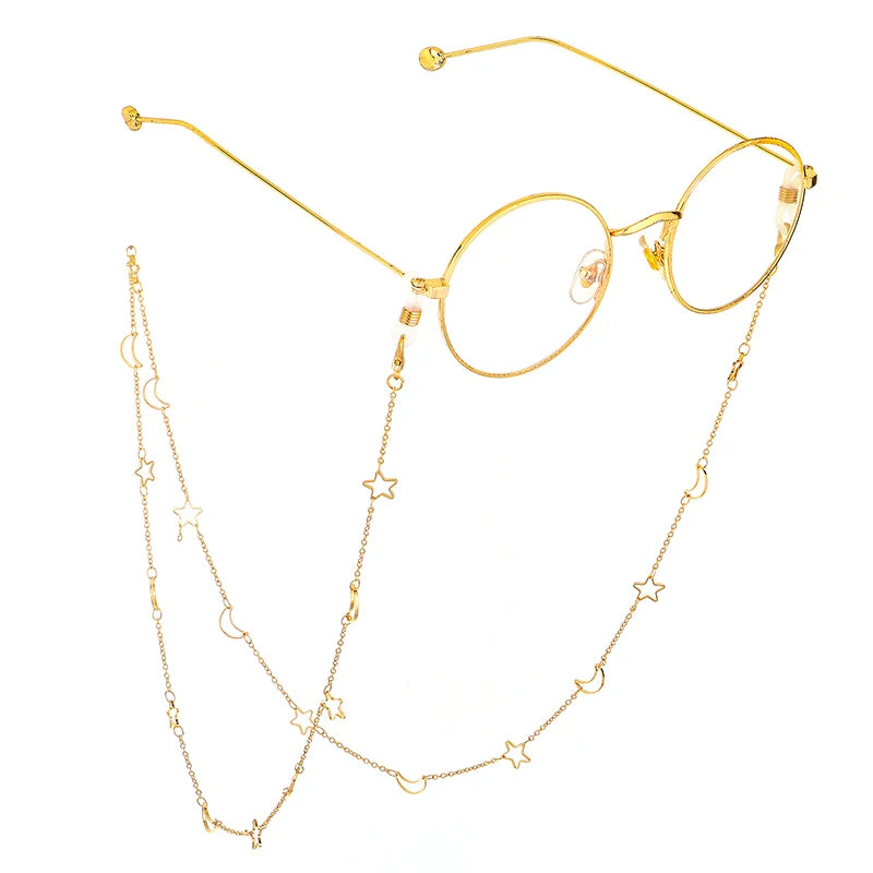 Gold-toned eyeglasses with thin gold chain necklaces featuring star and moon charms