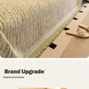A close-up of an elegant jacquard sofa cover blanket in a light beige color with subtle green embroidery.