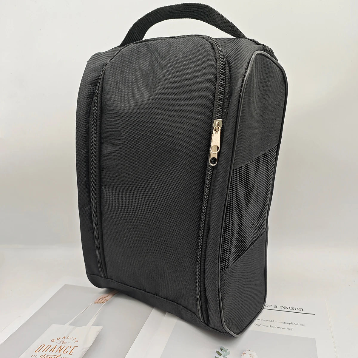 A black portable shoe carrier bag with a padded design and zipper visible against a light background.