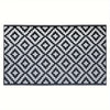 A black and white geometric pattern rug with diamond shapes.