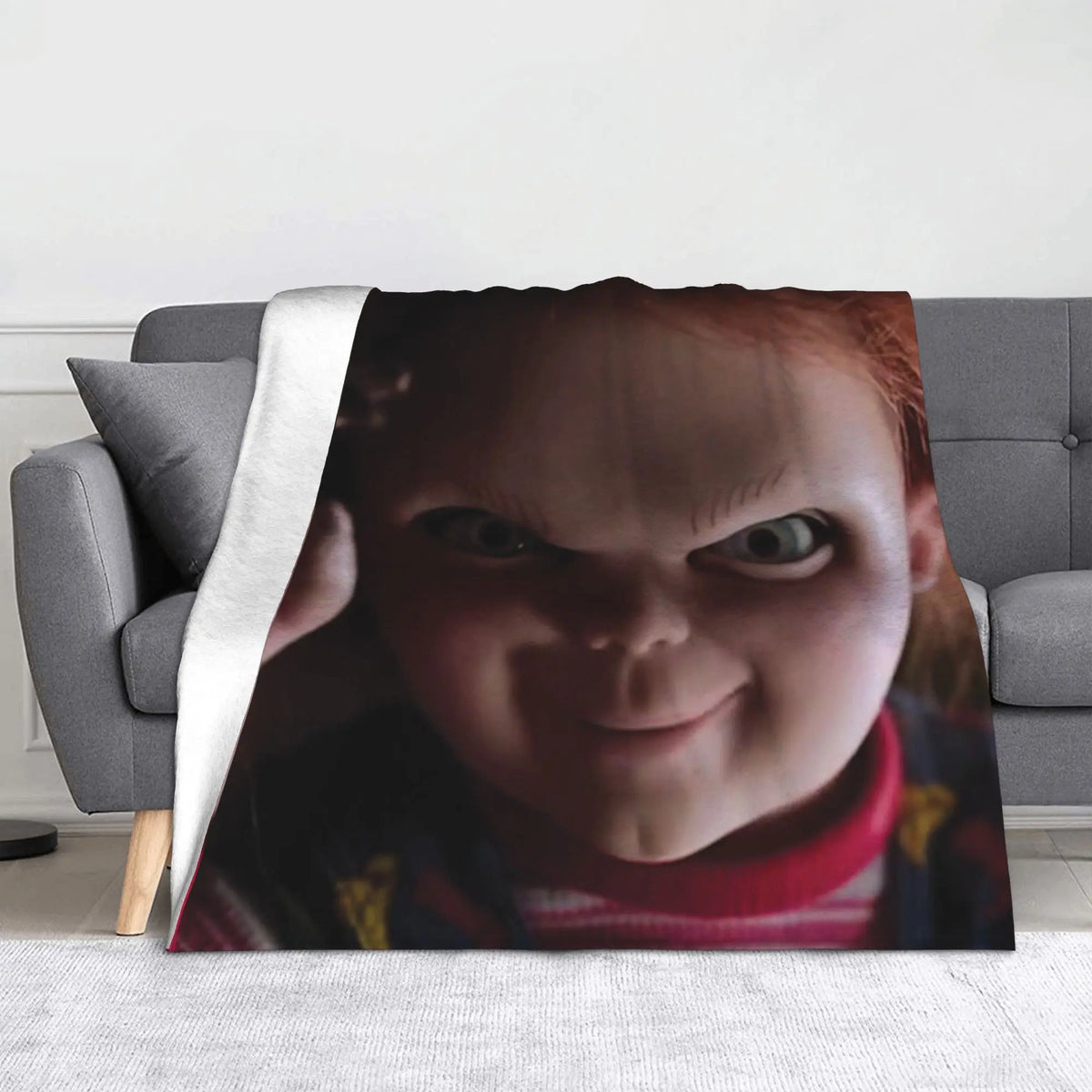 A flannel throw blanket featuring a close-up image of Chucky from the horror movie franchise.