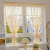 A window dressed with sheer beige lace curtains featuring a beaded phoenix tail design.