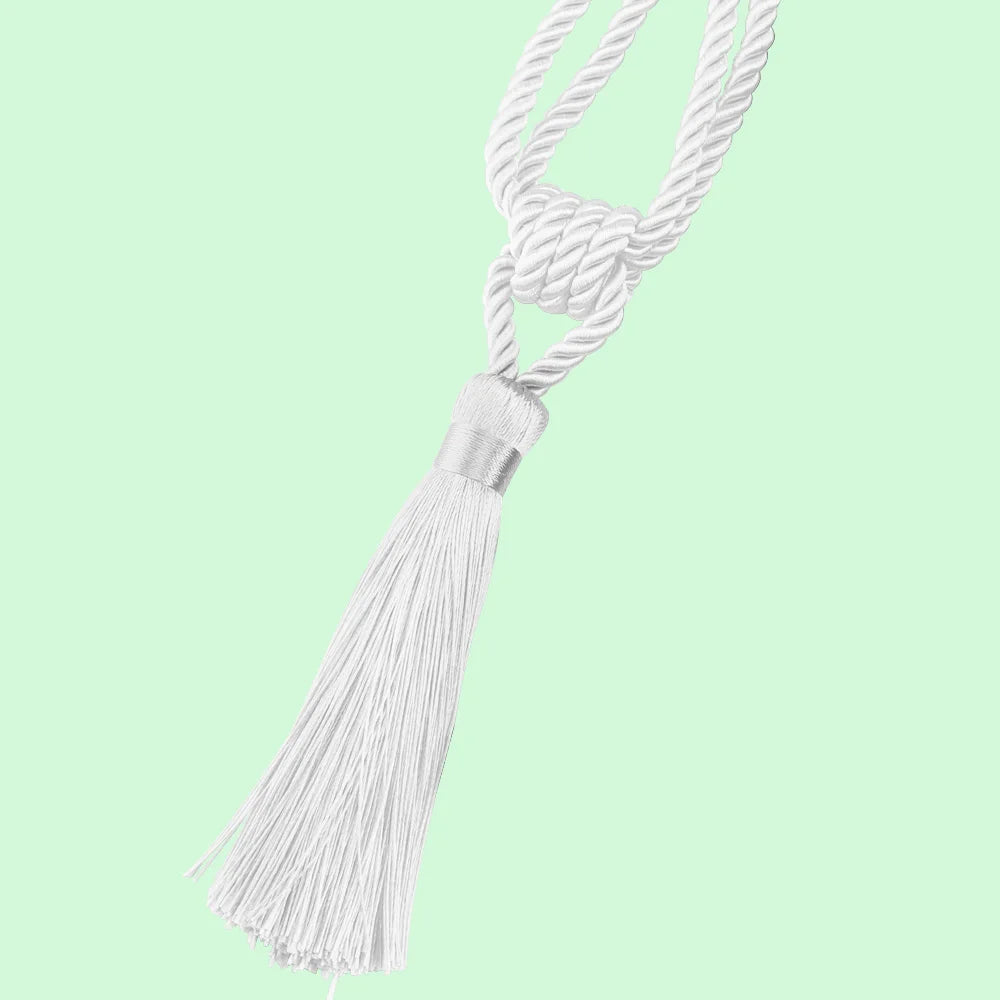Elegant white curtain tiebacks with braided cord and long tassels against a light green background
