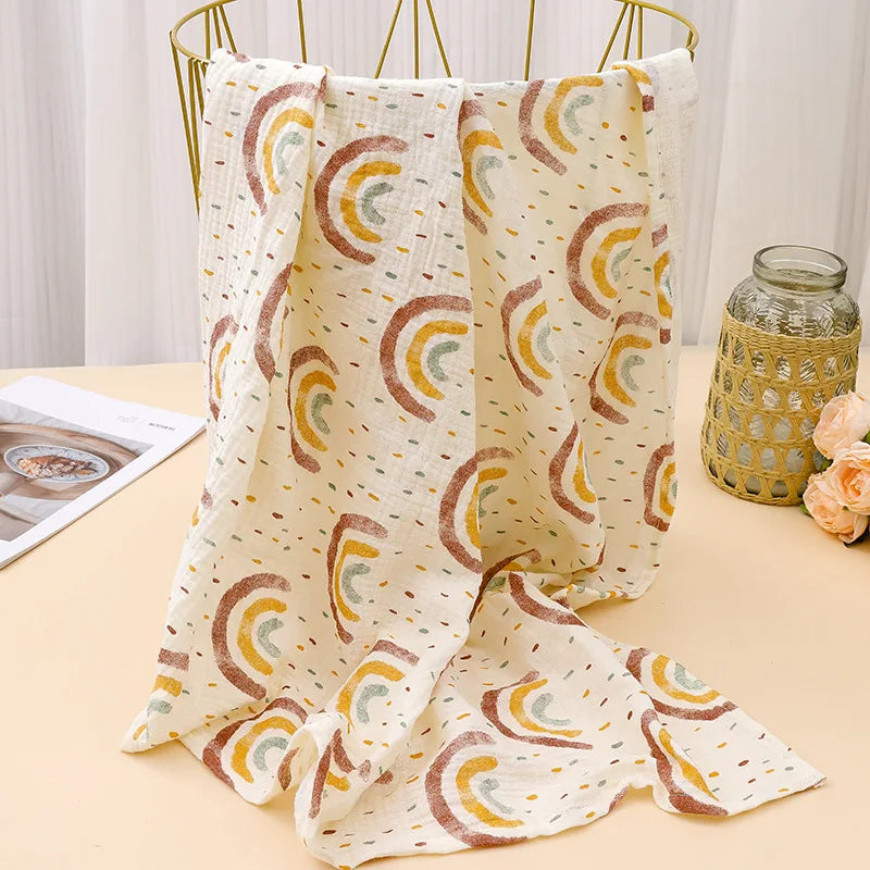 A beige and white printable cotton crib sheet draped on a gold hanger.