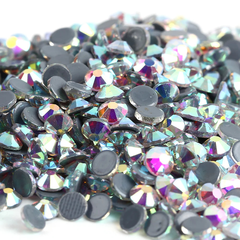 A pile of iridescent crystal AB flatback rhinestones in various shades of silver, blue, and purple.