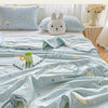 Light blue quilt blanket with a pastoral print featuring clouds, stars, and sheep on a bed.