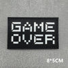Black embroidered patch with white text GAME OVER on a gray textured background
