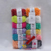 A collection of 12 colored milk cotton yarn skeins packaged for a crochet kit.