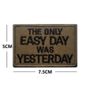 A rectangular brown embroidered patch with black text that reads THE ONLY EASY DAY WAS YESTERDAY