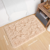 A rectangular cream tie-dye shaggy rug placed on a light wooden floor next to a bed and a wooden shelf.