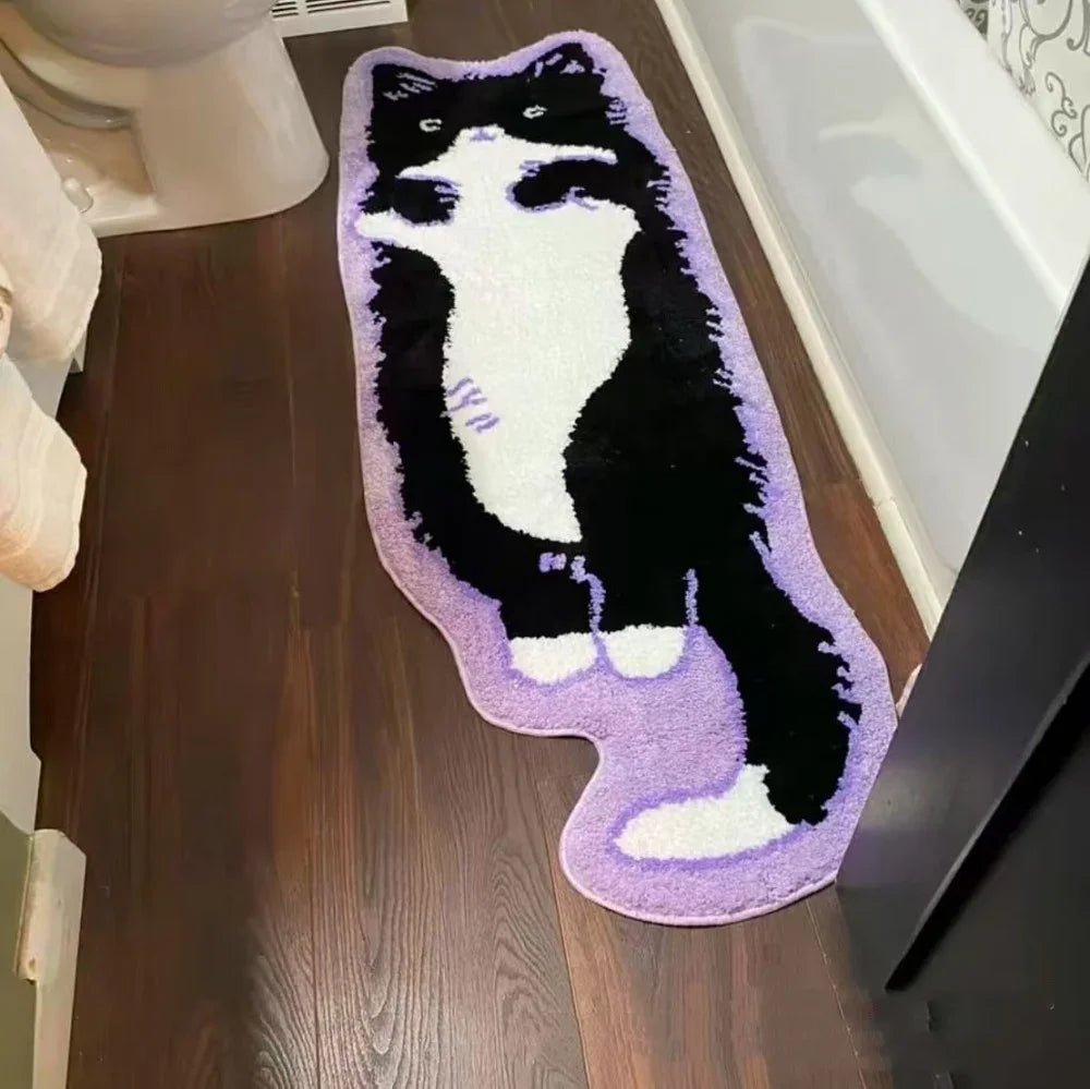 A plush rug shaped like a black and white cat with purple accents, used as a non-slip mat.
