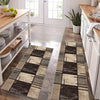 A modern checkered floor mat with black and beige geometric patterns placed on a light wood floor.