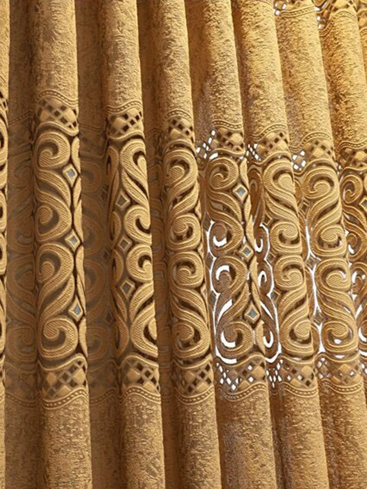 Close-up of a golden yellow hollow perforated curtain with intricate swirling patterns.