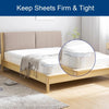 A close-up view of a bed with sheets secured by invisible corner tightener clips on the mattress.