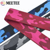 A close-up of various camouflage colored elastic stretch ribbons for sewing and craft projects.