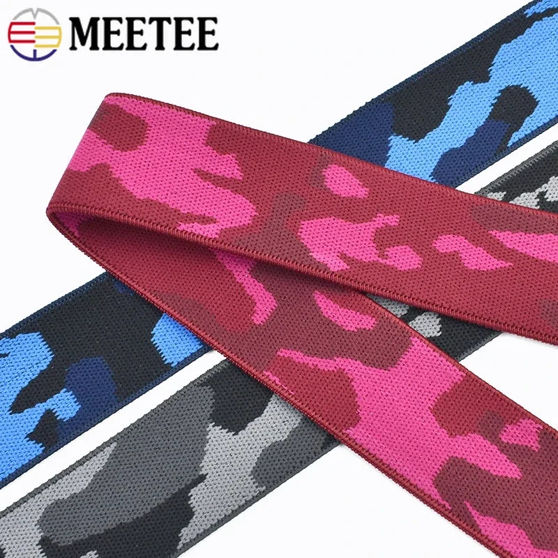 A close-up of various camouflage colored elastic stretch ribbons for sewing and craft projects.
