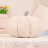 A fluffy, cream-colored 3D pumpkin shaped throw pillow for autumn decor resting on a white lace cloth.